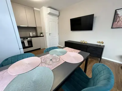 a dining room with a table and blue chairs at Harmony Apartment by 7th Sence in Sofia