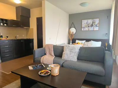 a living room with a couch and a table at Urban Atelier 300m from Gondola, Free Bottle of Wine, free Parking in Bansko