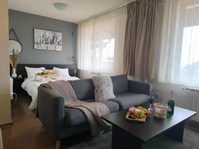 a living room with a couch and a bed at Urban Atelier 300m from Gondola, Free Bottle of Wine, free Parking in Bansko
