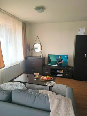 a living room with a blue couch and a tv at Urban Atelier 300m from Gondola, Free Bottle of Wine, free Parking in Bansko