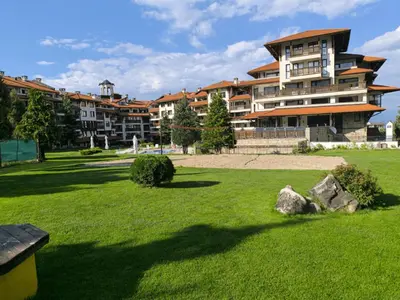 a large building in a park with green grass at Urban Atelier 300m from Gondola, Free Bottle of Wine, free Parking in Bansko