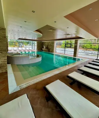 a swimming pool with benches in a building at Apartment Alex in Borovets