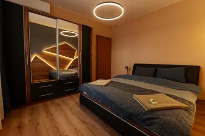 a bedroom with a bed and a dresser with a mirror at 1 minute to main Street Grafa, NDK, FREE Parking, 3BDR in Sofia