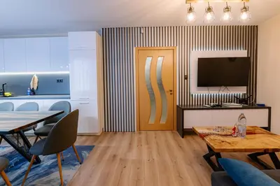 a living room with a television and a table and chairs at 1 minute to main Street Grafa, NDK, FREE Parking, 3BDR in Sofia