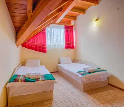 two beds in a room with a window at Stylish Two-Level Apartment in Bansko by Flat Mаnаger in Blagoevgrad