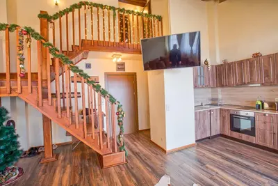 a living room with a staircase with a flat screen tv at Stylish Two-Level Apartment in Bansko by Flat Mаnаger in Blagoevgrad