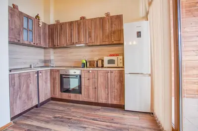 a kitchen with wooden cabinets and a white refrigerator at Stylish Two-Level Apartment in Bansko by Flat Mаnаger in Blagoevgrad