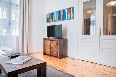 a living room with a tv and a wooden table at Big Apartment in Center Sofia - 2 BD - Fireplace in Sofia