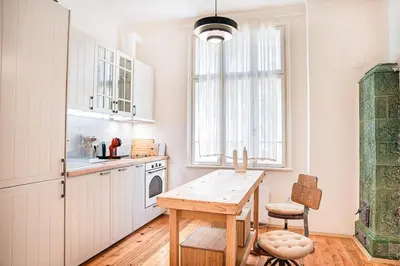 a kitchen with white cabinets and a wooden table at Big Apartment in Center Sofia - 2 BD - Fireplace in Sofia
