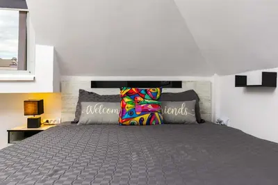 a bedroom with a large gray bed with pillows at Top-Floor Flat with Balcony by Flat Manаger in Plovdiv