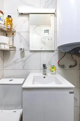 a white bathroom with a sink and a toilet at Top-Floor Flat with Balcony by Flat Manаger in Plovdiv