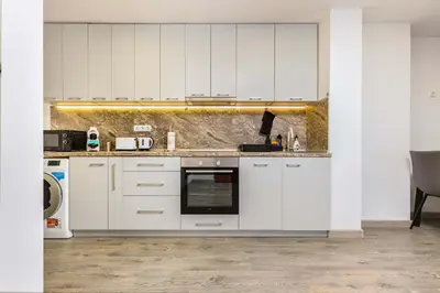 a kitchen with white cabinets and a sink at Top-Floor Flat with Balcony by Flat Manаger in Plovdiv