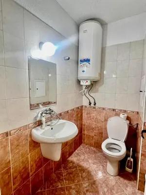 a bathroom with a toilet and a sink at Urban Glow Apartment near Metro Station in Sofia