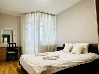 a bedroom with a large white bed with a window at Urban Glow Apartment near Metro Station in Sofia