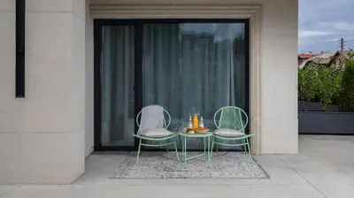 two chairs and a table in front of a window at Unique Designer Retreat | Mins to Gondola - Patio! in Bansko