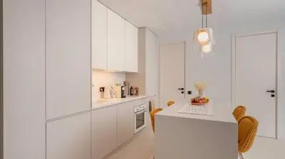 a kitchen with white cabinets and a table with chairs at Unique Designer Retreat | Mins to Gondola - Patio! in Bansko