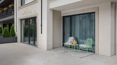 two chairs and a table in front of a building at Unique Designer Retreat | Mins to Gondola - Patio! in Bansko