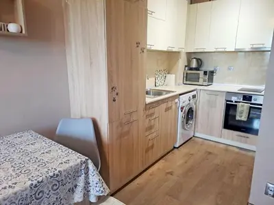 a kitchen with a table and a sink and a stove at LevskiG Family Flat 10 min from Sofia Airport and city center in Sofia