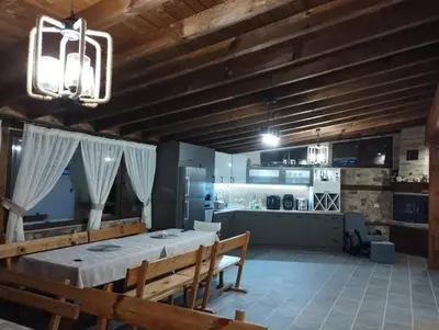 a large dining room with a table and a kitchen at Странската изба град Калофер in Kalofer