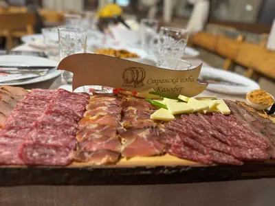 a tray of meat and cheese on a table at Странската изба in Kalofer