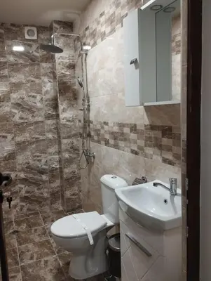 a bathroom with a toilet and a sink and a shower at Странската изба in Kalofer