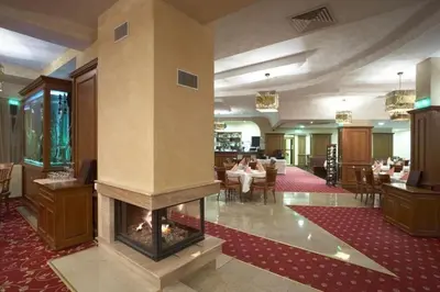 a lobby with a fireplace in the middle of a restaurant at Mountain View Studio Borovets Hills A60 in Borovets