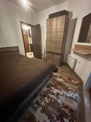 a bedroom with a bed and a wooden dresser at Winter Lotos Apartment Pamporovo in Pamporovo