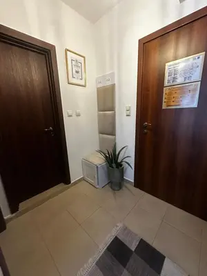 a hallway with a wooden door and a potted plant at Winter Lotos Apartment Pamporovo in Pamporovo