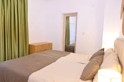 a bedroom with a bed with a green curtain at Villa Natalia in Kremen