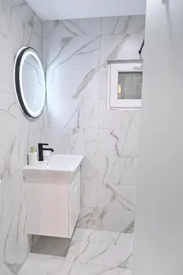 a white bathroom with a sink and a mirror at Villa Natalia in Kremen