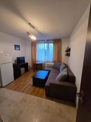 a living room with a couch and a table at Апартамент Kosara 44 in Bansko