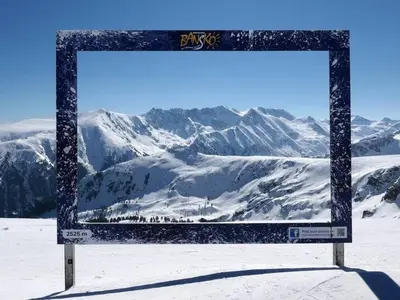 a sign in the snow with mountains in the background at Best Central Lux Studio in Bansko