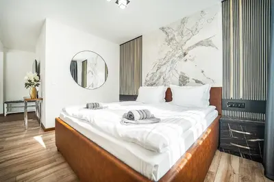a bedroom with a large bed with white sheets at Best Central Lux Studio in Bansko
