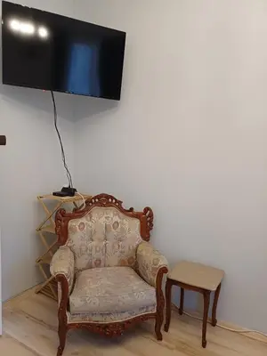 a room with a chair and a tv on a wall at Ktt house in Plovdiv