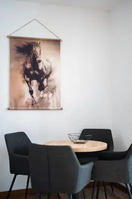 a table with chairs and a painting of a horse at Best Central LUX Studio in Bansko