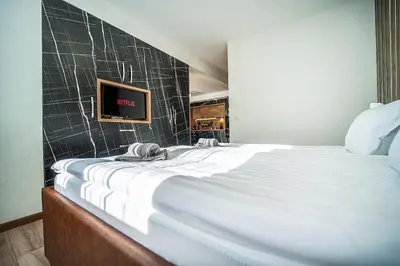 a bedroom with a large bed with a tv on the wall at Best Central LUX Studio in Bansko