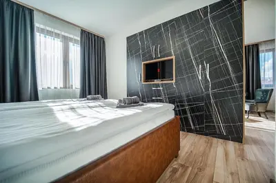 a bedroom with a large bed and a tv on a wall at Best Central LUX Studio in Bansko