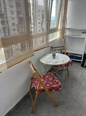 a room with a table and two chairs and a table and window at Angels Loft opposite The Mall in Sofia
