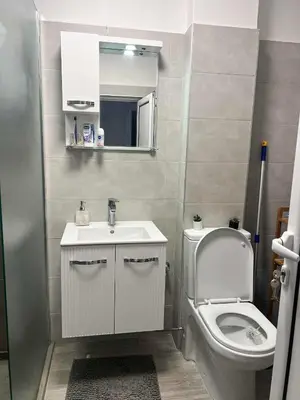 a bathroom with a toilet and a sink and a mirror at Angels Loft opposite The Mall in Sofia