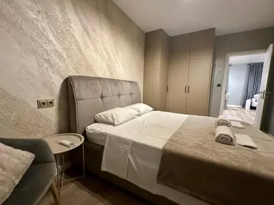 a bedroom with a large bed and a chair at Casa Nova with Free Garage Parking in Plovdiv