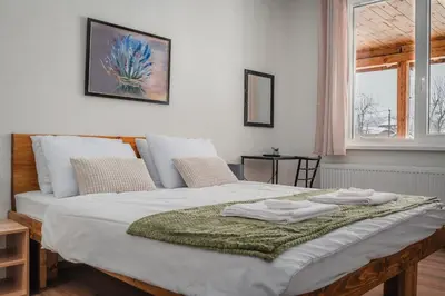 a bedroom with a bed with a green blanket on it at Guest house ''Viktoria'' in Simitli