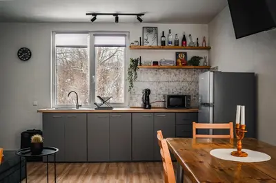 a kitchen with a wooden table and a refrigerator at Guest house ''Viktoria'' in Simitli