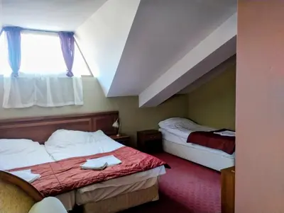 a hotel room with two beds and a window at хотел София in Bansko