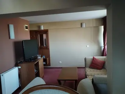 a living room with a couch and a tv at хотел София in Bansko