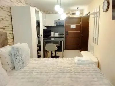 a bedroom with a white bed and a desk at Luxury studio Perun Lodge in Bansko