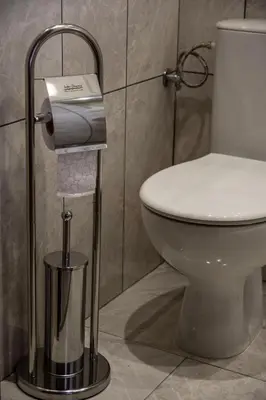 a toilet in a bathroom with a toilet paper dispenser at Dzhorgovata Guesthouse in Govedartsi