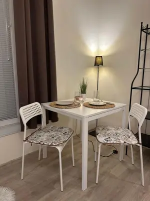 a white table with two chairs and a table with plates on it at Vinny's Place in Sofia