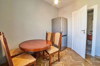 a dining room table with chairs and a refrigerator at Fabulous Retro Apartment in the Heart of Sofia in Sofia