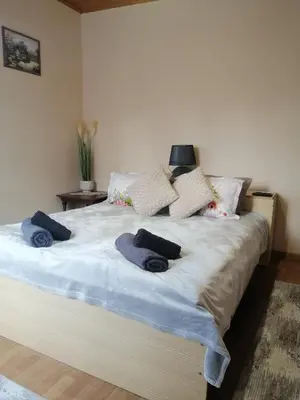 a bedroom with a large bed with blue towels on it at Уют in Haskovo