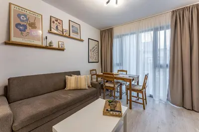 a living room with a couch and a table at Bright and Cozy Apartment at a quiet Location in Sofia
